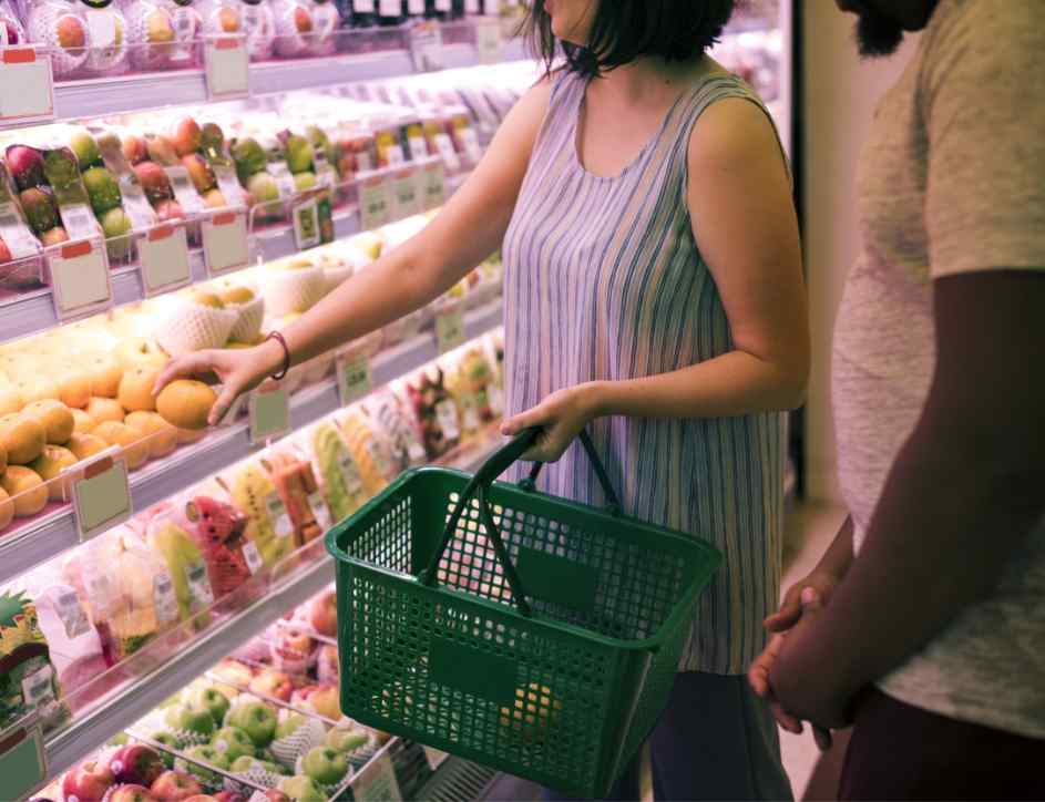 people picking up products from a supermarket shelf